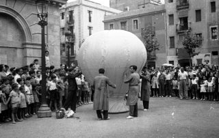 Fotografia antiga en blanc i negre d'una activitat popular a una plaça