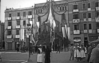 Fotografia antiga en blanc i negre d'una celebració popujar amb infermeres i guàrdies civils a l'ajuntament de Gràcia